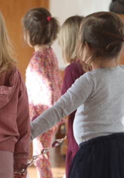 Tańczące dzieci odwrócone tyłem do kamery.