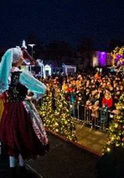 Na zdjęciu artyści w strojach ludowych stoją na scenie przed publicznością.