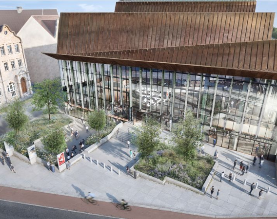 Widok z lotu ptaka na szklano-drewnianą bryłę budynku.