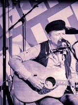 Biało-czarne zdjęcie artysty na scenie.