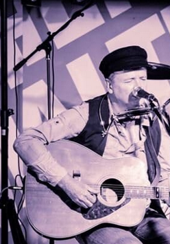 Biało-czarne zdjęcie artysty na scenie.