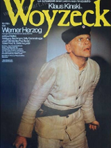 Plakat filmu o tytule Woyzeck, na którym oprócz informacji o wydarzeniu widać żołnierza w białym mundurze i okrągłej czapce.