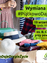 Na stole rozłozone różne rzeczy: ubrania, zabawki, torby, kapelusze. Za stołem stoją dwie kobiety i rozmawiają.