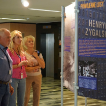 Zdjęcie, grupa osób ogląda wystawę w holu Urzędu Wojewódzkiego w Poznaniu.