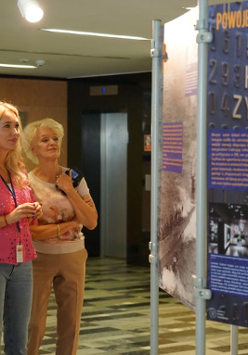 Zdjęcie, grupa osób ogląda wystawę w holu Urzędu Wojewódzkiego w Poznaniu.
