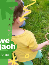 Baner, po lewej stronie na zielonym tle opis wydarzenia, po prawej zdjęcie dziecka bawiącego się na trawie.