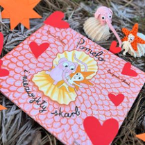 Okładka książki o słoniu Pomelo. W centralnej części słoń i jego przyjaciel, dookoła czerwone serduszka. Napis: Pomelo i niezwykły skarb.