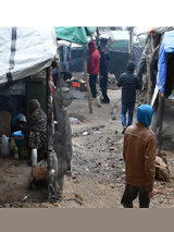 Zdjęcie wykonane na wyspie Lesbos: grupa ludzi na placu przypominającym targowisko