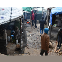 Zdjęcie wykonane na wyspie Lesbos: grupa ludzi na placu przypominającym targowisko