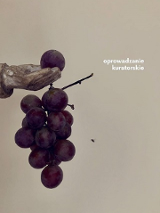Fragment ekspozycji - dłoń trzymająca kiść winogron