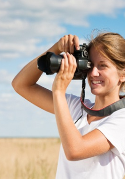 Dziewczyna z aparatem na łące