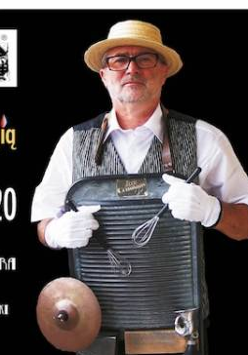 Na zdjęciu starszy mężczyzna w kapeluszu słomkowym - muzyk z przewieszoną przez szyją tarką i trzepaczkami.