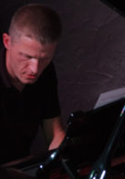 Na zdjęciu artysta przy fortepianie.