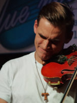 Zdjęcie muzyka grającego na skrzypcach.