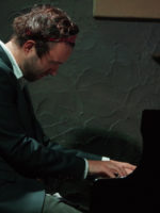 Zdjęcie artysty przy fortepianie.