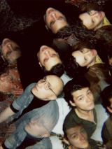 Na zdjęciu twarze kilku osób patrzących w górę.