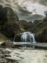 Na zdjęciu górzysty krajobraz z niewielkim wodospadem.
