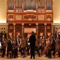 Na zdjęciu zespół muzyczny na scenie w auli UAM. W tle organy.