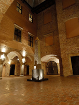 Zdjęcie oświetlonego dziedzińca Muzeum Archeologicznego. W centralnej części obelisk Ramzesa II.