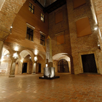 Zdjęcie oświetlonego dziedzińca Muzeum Archeologicznego. W centralnej części obelisk Ramzesa II.