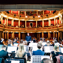 Zdjęcie pokazuje orkiestrę i widownię Teatru Nowego. Zdjęcie zrobione z ostatniego rzędu w orkiestrze.