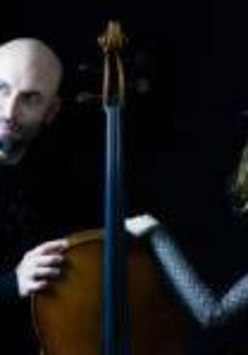 Na zdjęciu na czarnym tle dwie postaci opierające się dłońmi o kontrabas.