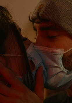 Na zdjęciu całujące się dwie postaci w maseczkach.