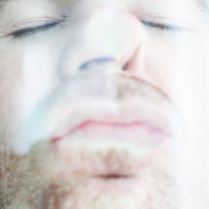 Mężczyzna całuje szybę, przyciskając do niej twarz. Widzimy to zza szyby.