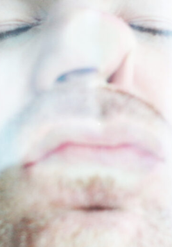 Mężczyzna całuje szybę, przyciskając do niej twarz. Widzimy to zza szyby.