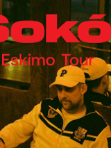 Raper w czapce i bluzie sportowej siedzi w barze, za nim lustro. Czerwony napis Sokół Eskimo Tour.