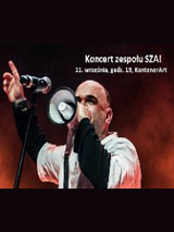 Wokalista w trakcie koncertu. W tle biały napis z datą wydarzenia.