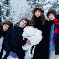 Cztery młode dziewczyny w zimowej scenerii.