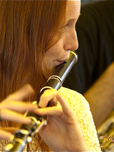 Kobieta grająca na flażolecie.