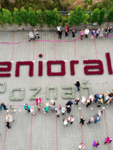 Zdjęcie seniorów wokół napisu "senioralni Poznań".