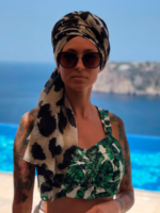 Na zdjęciu wokalistka zespołu na tle błękitnego morza i klifów..