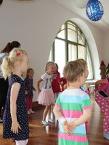 Zdjęcie z zajęć cyklu Strefa Zabawy. Zgromadzone w Bawialni dzieci tańczą pod kierunkiem prowadzących.