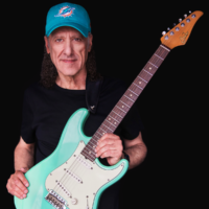 Na zdjęciu artysta z gitarą.