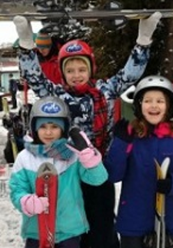 Grupa dzieci w zimowych kurtkach na dworze.