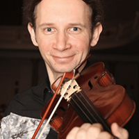 Na zdjęciu Marcin Herman grający na skrzypcach.