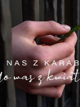 Na zdjęciu ręce z przebiśniegiem wystające zza krat. Na nadgarstku lewej ręki biało-czerwono-biała opaska.