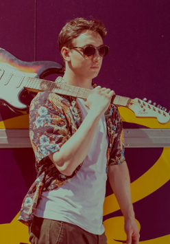 Na zdjęciu Wojtek idący z gitarą na ramieniu.