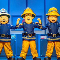 Zdjęcie ze spektaklu, na którym widoczne są 3 osoby w strojach strażaków