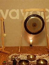 na zdjęciu widoczne jest pomieszczenie, w którym stoją dwa gongi; na podłodze rozłożone są świeczki