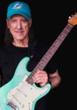 Na zdjęciu artysta z gitarą.