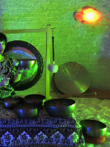 Kobieta trzymająca w ręku misę. W tle widoczny gong.