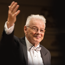 na zdjęciu dyrygent prowadzący koncert.