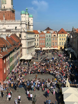 Zdjęcie zrobione podczas wcześniejszych świętowań. Duża grupa uczestników na płycie Starego Rynku w Poznaniu.