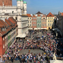 Zdjęcie zrobione podczas wcześniejszych świętowań. Duża grupa uczestników na płycie Starego Rynku w Poznaniu.