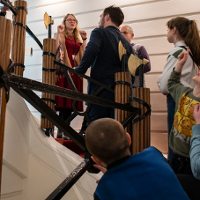 Na zdjęciu grupa ludzi na schodach, we wnętrzach Biblioteki Raczyńskich.