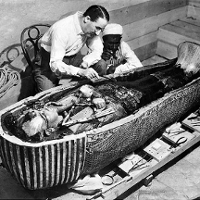 Zdjęie archeologa nad otwartym sarkofagiem.
